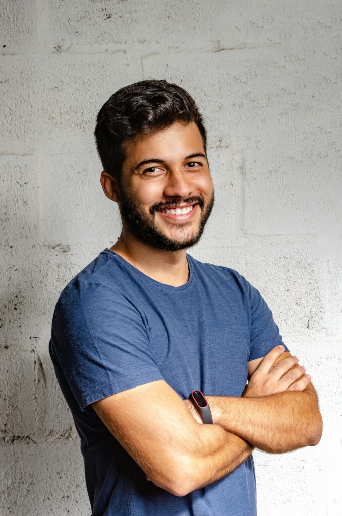pexels-photo-2379004-2379004 Portrait of a happy man with arms crossed, exuding confidence and friendliness.