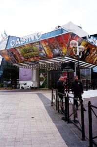 A colorful casino entrance with two security guards and decorative artwork.
